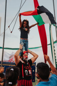 Niña ondeando la bandera palestina en brazos de Iván Prado
